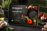 E-kniha 53 receptů z kalendáře 2025 na tabletu opřeném na tmavé kuchyňské lince proti zeleným kachlíkům, kolem rozmarýn v hmoždíři, karafa olivového oleje, talíř žampionů, rajčata na větvičce a česnek
