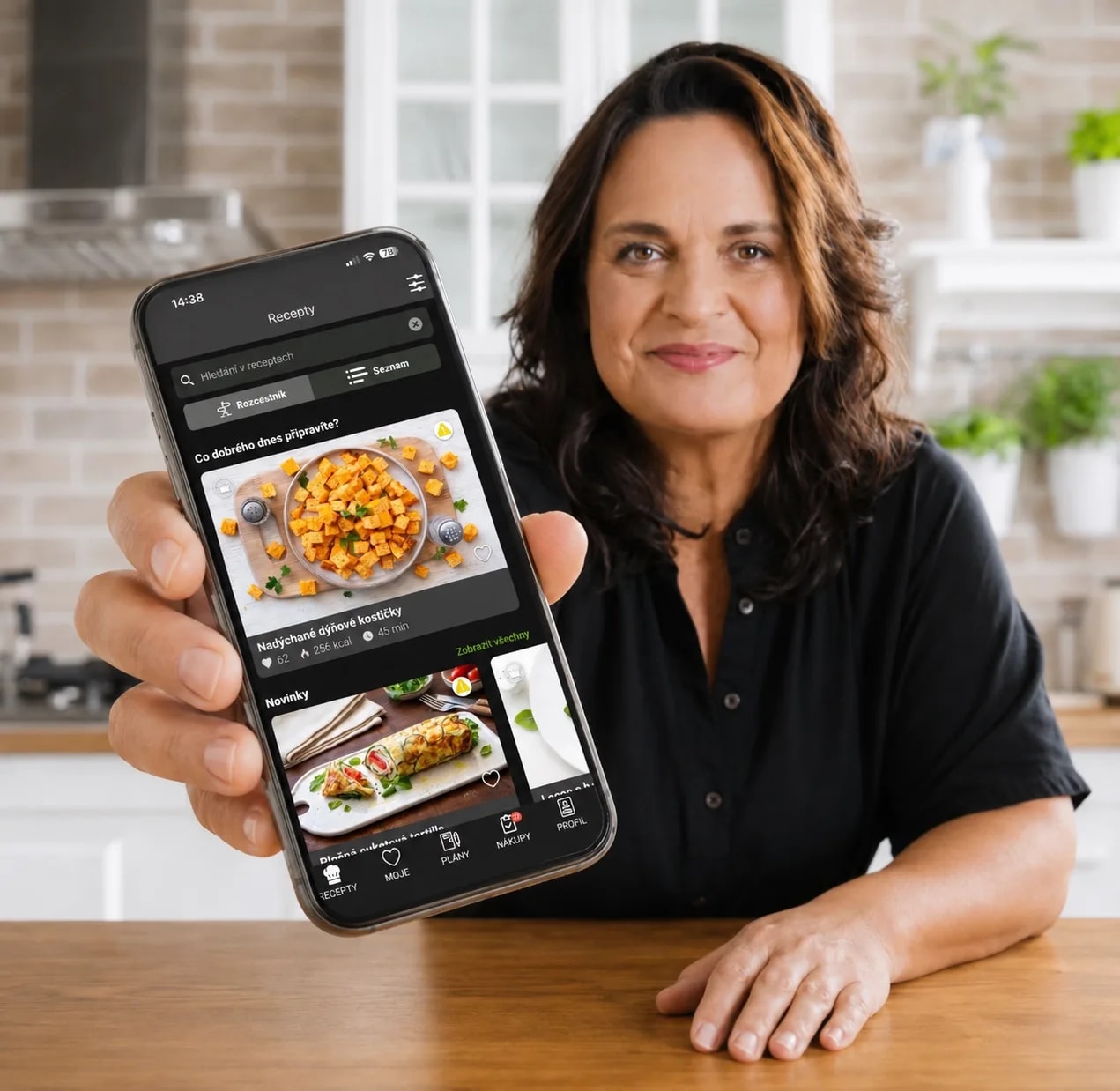 Lucie Grusová drží v ruce mobilní telefon se spuštěnou aplikací PaleoSnadno plnou zdravých bezlepkových receptů.