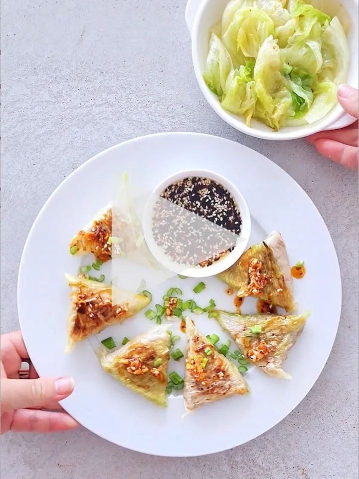 Asijské vepřové knedlíčky (obalené v pórku), dip z balzamikového octa, sezamového oleje a sezamu, křupavý chilli olej, spařený ledový salát